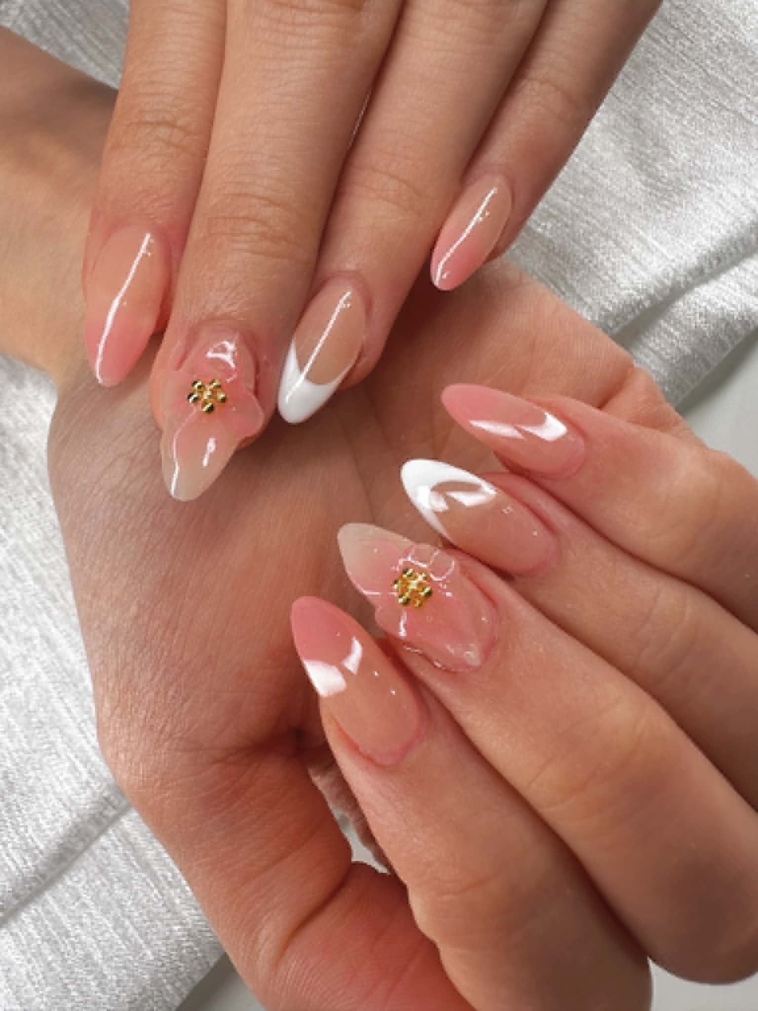 Sheer pink almond nails with 3D flower accents